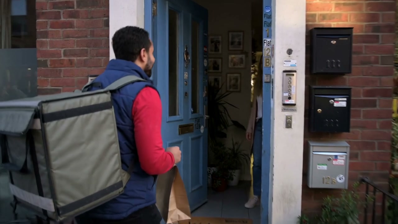 An independent courier completing a sealed food delivery